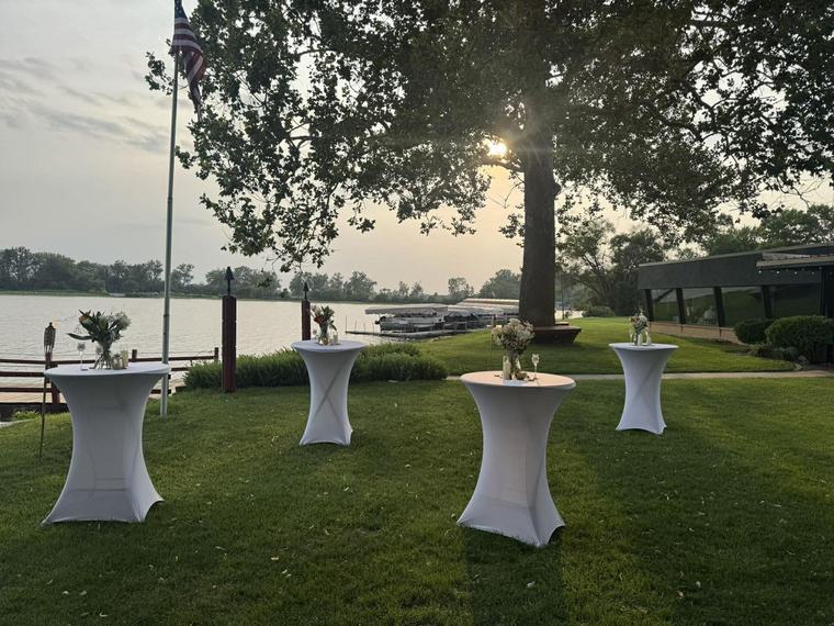 Cocktail tables set out by the water at sunset