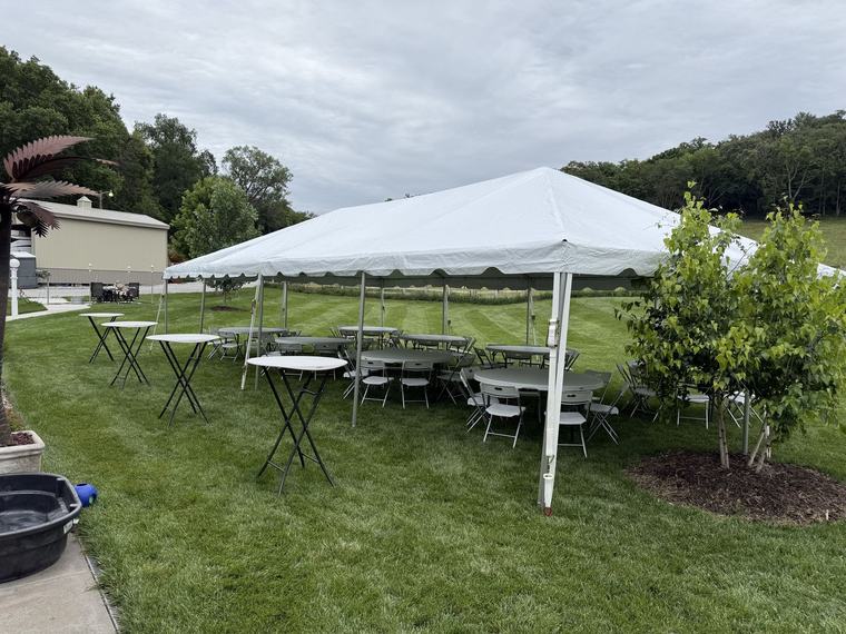 Tent, tables and chairs arranged on a lawn