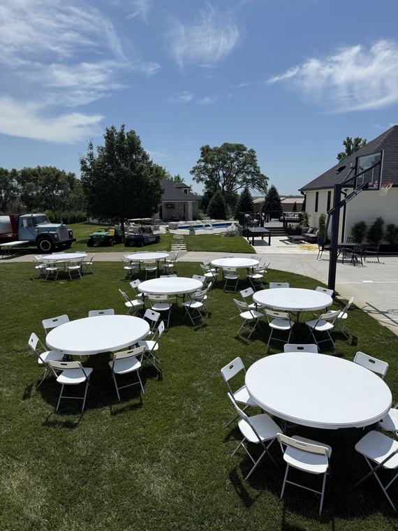 Round tables and chairs laid out on a driveway before guests arrive